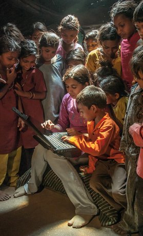 Un voluntario comparte un ordenador con niños de una aldea en el distrito de Dhar, India. © 2009 Chetan Soni, Photoshare